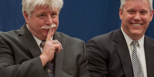 Dennis “Red” Gendron, left, gestures animatedly during a press conference where he was introduced as the new men's hockey coach by Athletic Director Steve Abbott, right, at the University of Maine, Tuesday, May 28, 2013, in Orono, Maine. (AP Photo/Michael C. York)