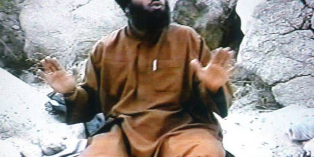 In this undated Photo taken from video and provided by the United States Attorney’s Office for the Southern District of New York, defendant Suliman Abu Ghayth, sits on the ground somewhere in Afghanistan. Abu Ghayth, is being tried in New York for plotting to kill Americans by being a motivational speaker at al-Qaida training camps before the Sept. 11 attacks and for serving as a spokesman for the terror group afterward. This photo was among the trial exhibits that the federal prosecutor showed the jury, sometimes repeatedly. (AP Photo/US Attorney’s Office for the Southern District of New York)