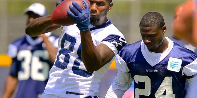 Dallas Cowboys cornerback Morris Claiborne (24) guards wide receiver Dez Bryant (88) as he makes a reception as they run plays during Dallas Cowboy's training camp, Friday, July 25, 2014, in Oxnard, Calif. (AP Photo/Gus Ruelas)