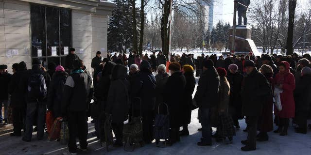 People queue to receive humanitarian aid from the charitable foundation of Ukrainian billionaire Rinat Akhmetov, whose vast wealth is founded on the industrial output of Donetsk coal-rich region, in Donetsk, Eastern Ukraine, Tuesday, Jan. 13, 2015. Akhmetov is contentious figure in eastern Ukraine. Although a major provider of employment, he is regarded with profound suspicion by much of the impoverished local population. Still, his standing improves with every consignment of goods that reaches separatist-held regions. Amnesty International said it received reports before the New Year holidays of volunteer battalions fighting alongside Ukrainian government forces of preventing the Akhmetov convoys from getting through. The battalion justified their actions by arguing that the food and clothes in the trucks could ultimately help to support the separatist cause, Amnesty says. (AP Photo/ Mstyslav Chernov)