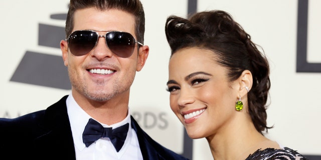 Singer Robin Thicke and wife, actress Paula Patton, arrive at the 56th annual Grammy Awards in Los Angeles, California January 26, 2014. REUTERS/Danny Moloshok (UNITED STATES TAGS: ENTERTAINMENT) (GRAMMYS-ARRIVALS) - RTX17W6V