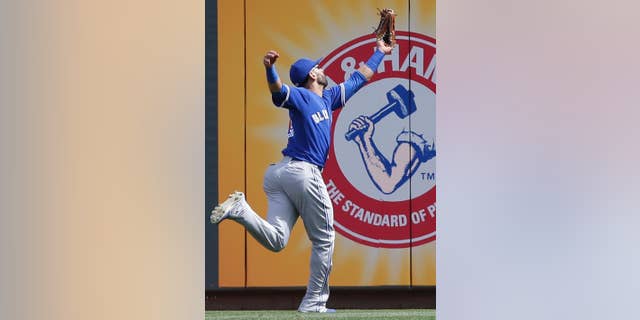 Toronto Blue Jays right fielder Jose Bautista catches a line drive hit by Cincinnati Reds' Todd Frazier in the first inning of a baseball game on Saturday, June 21, 2014, in Cincinnati. (AP Photo/Al Behrman)