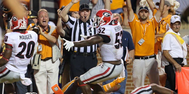 Tennessee's Alton Howard, bottom left, falls into the endzone after he fumbled the ball for a turnover as Georgia's Amarlo Herrera (52) contents the original call as a touchdown in overtime of an NCAA college football game in Knoxville, Tenn., Oct. 5, 2013. (AP Photo/Atlanta Journal-Constitution, Jason Getz)