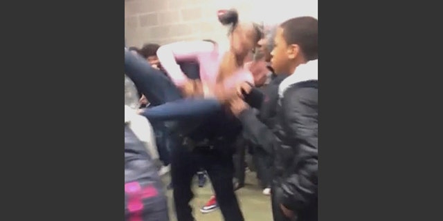 In this Tuesday, Jan. 3, 2017, image made from video and released by Pam C. Akpuda, officer Ruben De Los Santos of the Rolesville Police Department slams a teenage girl to the floor in Rolesville, N.C. The student who was slammed to the ground by a police officer was trying to break up a fight involving her sister, said the 15-year-old who posted video of the incident. (Pam C. Akpuda via AP)