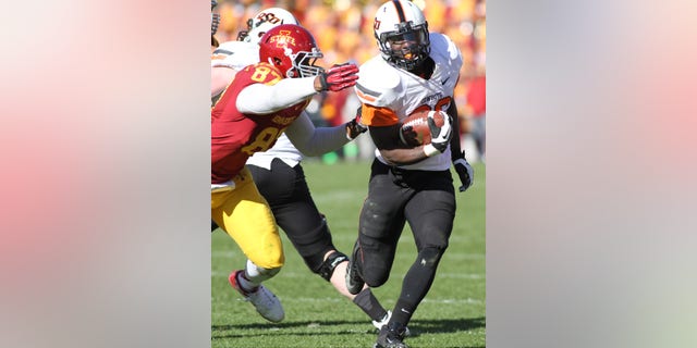 Oklahoma State running back Desmond Roland (26) breaks away from Iowa State defensive lineman David Irving (86) during the second half of an NCAA college football game in Ames, Iowa Saturday, Oct. 26, 2013. Oklahoma State won the game 58-27.(AP Photo by Justin Hayworth)