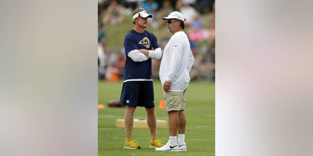 St. Louis Rams head coach Jeff Fisher, right, talks with Rams general manager Les Snead during training camp at the NFL football team's practice facility on Saturday, July 26, 2014, in St. Louis. (AP Photo/Jeff Roberson)