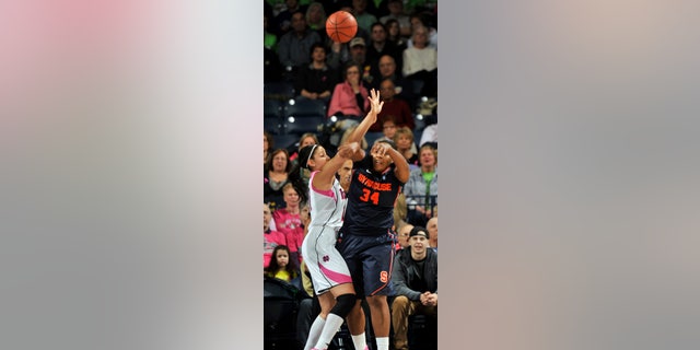 Syracuse center Shakeya Leary, right, passes as Notre Dame forward Natalie Achonwa defends during first-half action of an NCAA college basketball game on Sunday, Feb. 9, 2014, in South Bend, Ind. (AP Photo/Joe Raymond)