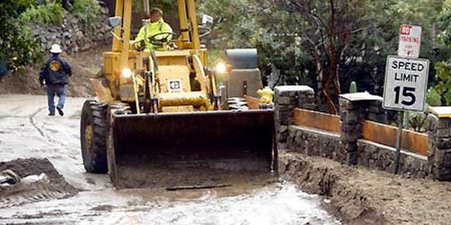 Feb. 7: Heavy equipment removes mudflow on Woodland Drive in Sierra Madre, Calif.