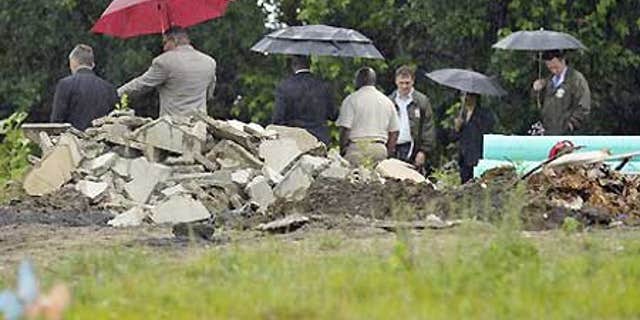 July 8: Authorities at Burr Oak Cemetery in Alsip, Ill., where dozens of graves were dug up and bodies dumped in a massive pile.