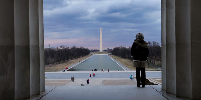 This Feb. 28, 2013 photo shows a visitor viewing the National Mall from the Lincoln Memorial looking towards the Washington Monument and the U.S. Capitol in Washington. There are probably more free things to do in the U.S. capital than nearly any other major city in the world. The most popular museums and the zoo are free, thanks to government funding, as well as the picturesque memorials and monuments. With so many free options, the biggest challenge might be narrowing down what to see. (AP Photo/Alex Brandon)