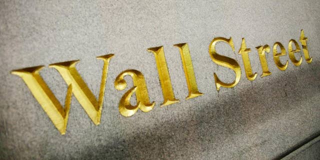 FILE - This Oct. 8. 2014 photo shows a Wall Street address carved into the side of a building in New York. U.S. stock indexes are opening lower Monday, April 6, 2015 following a weak jobs report late last week. (AP Photo/Mark Lennihan, File)