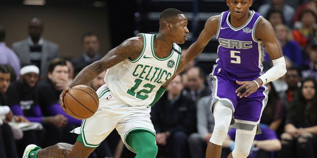 Boston Celtics guard Terry Rozier (12) drives around Sacramento Kings guard De'Aaron Fox (5) during the first half of an NBA basketball game in Sacramento, Calif., Sunday, March 25, 2018.