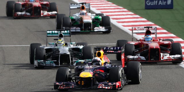 Red Bull driver Sebastian Vettel of Germany, center, leads Ferrari driver Fernando Alonso of Spain, right, and Mercedes driver Nico Rosberg of Germany, during the Formula One Grand Prix at the Formula One Bahrain International Circuit in Sakhir, Bahrain, Sunday, April 21, 2013. (AP Photo/Hassan Ammar)