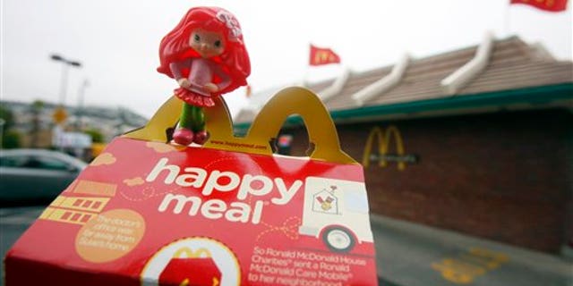 FILE - In this Oct. 1, 2010 file photo, a Happy Meal box and toy are shown outside of a McDonald's restaurant in San Francisco. City lawmakers on Tuesday, Nov. 2, 2010, approved legislation that they hope will force fast-food chains such as McDonald's to make their children's meals healthier or stop selling them with toys. (AP Photo/Jeff Chiu, File)