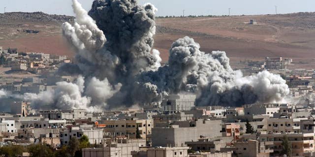 Oct. 22, 2014: Thick smoke from an airstrike by the US-led coalition rises in Kobani, Syria, as seen from a hilltop on the outskirts of Suruc, at the Turkey-Syria border. Kobani, also known as Ayn Arab, and its surrounding areas, has been under assault by extremists of the Islamic State group since mid-September and is being defended by Kurdish fighters.