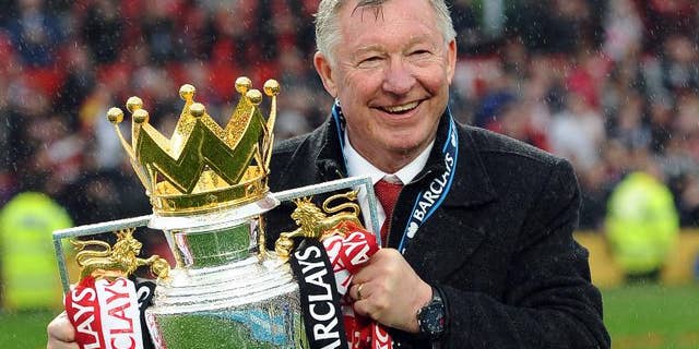 Then Manchester United manager Alex Ferguson holds the Premier League trophy after a match against Swansea City at Old Trafford in Manchester on May 12, 2013