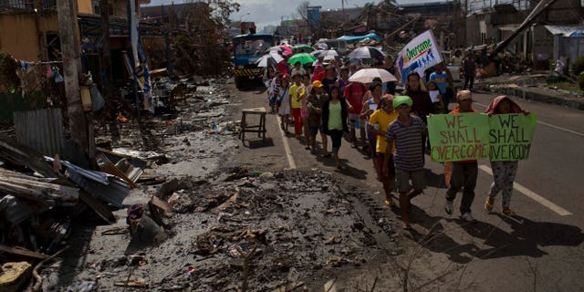 People march in the rain Tacloban, Philippines during a procession to call for courage and resilience among their Typhoon Haiyan survivors on Tuesday Nov. 19, 2013. In the wake of every major global catastrophe, the world’s media dutifully broadcasts the traditional narrative of grief and despair. Stories of loss and desperation were ubiquitous in Haiyan as well, and rightly so: more than 4,000 people were killed in the storm’s first few hours, and blackened bodies with skin peeling are still trapped under the rubble today. But as the crisis eases and aid begins to flow, there is another side to the story that rarely gets beamed out _ people smiling (if only briefly), people joking (if only in passing). (AP Photo/David Guttenfelder)
