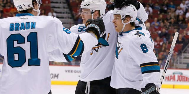 San Jose Sharks' Joe Pavelski (8) celebrates his second goal in the first period of an NHL hockey game against the Phoenix Coyotes with teammates Justin Braun (61) and Matt Irwin (52) on Saturday, April 12, 2014, in Glendale, Ariz. (AP Photo/Ross D. Franklin)