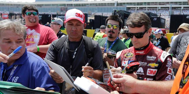 Jeff Gordon signs autographs before practice for Sunday's NASCAR Coca-Cola 600 Sprint Cup series auto race at Charlotte Motor Speedway in Concord, N.C., Thursday, May 21, 2015. (AP Photo/Chuck Burton)