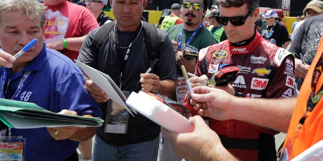 Jeff Gordon signs autographs before practice for Sunday's NASCAR Coca-Cola 600 Sprint Cup series auto race at Charlotte Motor Speedway in Concord, N.C., Thursday, May 21, 2015. (AP Photo/Chuck Burton)
