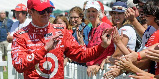 FILE - In this Aug. 4, 2013 file photo, Scott Dixon, of New Zealand, greets fans during driver introductions at the Honda Indy 200 at Mid-Ohio in Lexington, Ohio. Sponsors come and go in motor sports, where even the strongest partnerships can quickly unravel because of the economy, a difference of opinion or a change in marketing strategy. But Chip Ganassi has developed a partnership with Target that has lasted 25 years in counting, and the team owner considers the relationship with the retail giant a key element in the growth of his race team and Ganassi himself. (AP Photo/Tom E. Puskar, File)