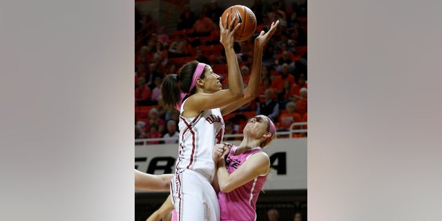 Oklahoma center Nicole Griffin, left, fouls Oklahoma State forward Liz Donohoe, right, while shooting in the first half of an NCAA college basketball game in Stillwater, Okla., Sunday, Feb. 16, 2014. (AP Photo/Sue Ogrocki)