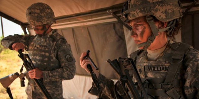 FILE: A female Army soldier tries on body armor.