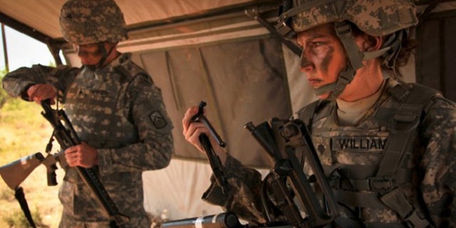 FILE: A female Army soldier tries on body armor.