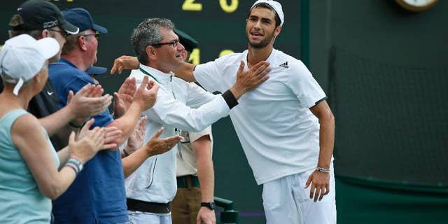 Noah Rubin of the U.S., right, is congratulated after defeating Stefan Kozlov of the U.S in the boys' singles final at the All England Lawn Tennis Championships in Wimbledon, London, Sunday July 6, 2014. (AP Photo/Alastair Grant)