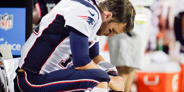 New England Patriots quarterback Tom Brady sits on the bench during the fourth quarter of an NFL football game against the Kansas City Chiefs Monday, Sept. 29, 2014, in Kansas City, Mo. The Chiefs won 41-14. (AP Photo/Charlie Riedel)