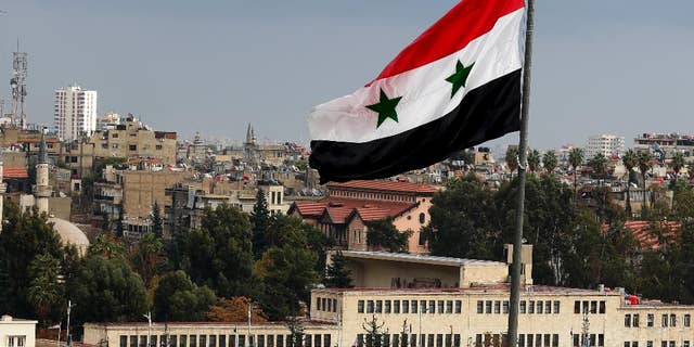 Cars are bumper to bumper on a bridge as they wait to be searched at a military checkpoint in Damascus, Syria, Thursday, Dec. 1, 2016. (AP Photo/Hassan Ammar)