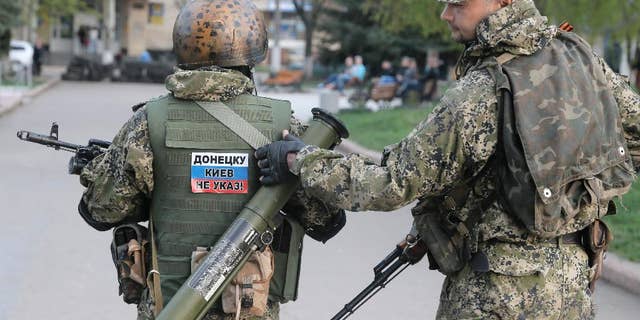 Pro-Russian gunman patrol a streets in downtown Slovyansk, Eastern Ukraine, Friday, April 18, 2014. Pro-Russian insurgents defiantly refused Friday to surrender their weapons or give up government buildings in eastern Ukraine, despite a diplomatic accord reached in Geneva and overtures from the government in Kiev. (AP Photo/Efrem Lukatsky)