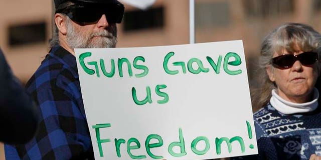 Jan. 9, 2013: Daniel White of Estes Park, Colo., waves a placard at a pro-gun rally as the Colorado Legislature opened its general session across the street in the State Capitol in Denver.