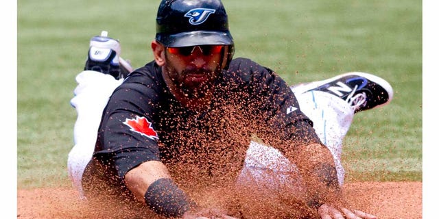Toronto Blue Jays' Jose Bautista slides safely into third base during sixth inning of a baseball game against the Philadelphia Phillies, Sunday, July 3, 2011, in Toronto. The Blue Jays defeated the Phillies 7-4. (AP Photo/The Canadian Press, Darren Calabrese)