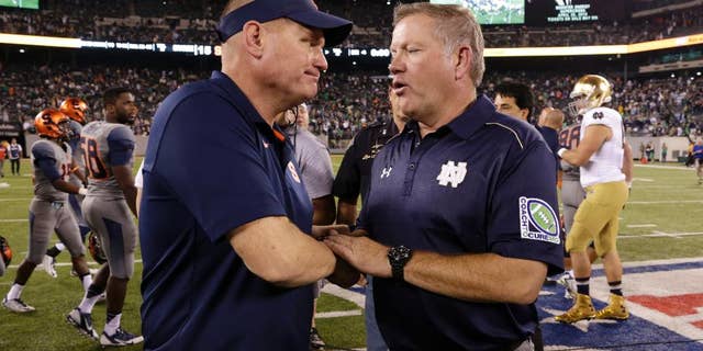 Syracuse coach Scott Shafer, left, and Notre Dame coach Brian Kelly shake hands after an NCAA college football game, Saturday, Sept. 27, 2014, in East Rutherford, N.J. Notre Dame won 31-15. (AP Photo/Julio Cortez)