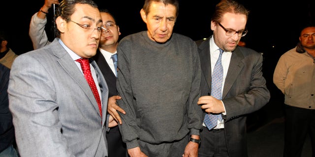 Retired Mexican Army General Tomas Angeles Dauahare, center, is escorted by unidentified members of his legal team as he leaves the Altiplano maximum security prison in Almoloya de Juarez, Mexico, Thursday, April 18, 2013. Federal prosecutors have dropped organized crime charges against Dauahare, accused of aiding a drug cartel after determining that the witness testimony was not enough to sustain their case. He had been in prison since last year, charged with protecting members of the Beltran Leyva cartel. (AP Photo)