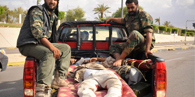 Oct. 13: Libyan revolutionary fighters transport their injured comrade in Sirte, Libya.