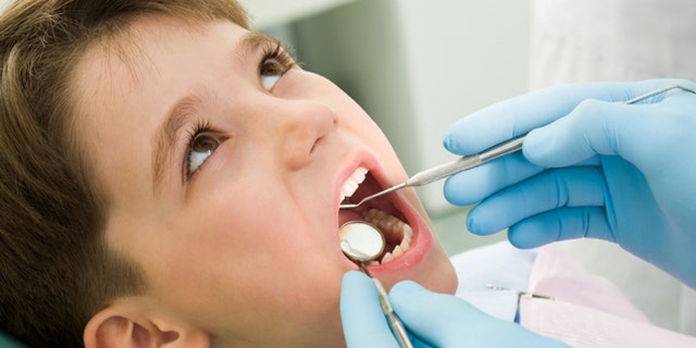 Close-up of little boy opening his mouth during dental checkup