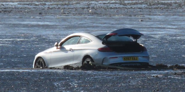 Please note mandatory credit - Burnham-on-Sea.com / SWNS
A man died of a heart attack as he tried to rescue this Mercedes from a beach. See SWNS story SWRESCUE; The member of the rescue team was trying to move a hire car wedged in mud. The vehicle had been rented by a couple and become stranded at Burnham-on-Sea in Somerset. A Coastguard team and a local commercial vehicle recovery service were called out to recover the Mercedes on Saturday as the tide moved in.