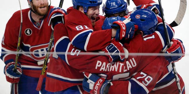 Montreal Canadiens right wing P.A. Parenteau (15) celebrates with teammates Andrei Markov (79), P.K. Subban (76), Lars Eller(81) and Brandon Prust, links, after scoring the winning goal against the Tampa Bay Lightning during the third period of Game 5 of a second-round NHL Stanley Cup hockey playoff series Saturday, Mei 9, 2015, in Montreal. (Ryan Remiorz/The Canadian Press via AP)