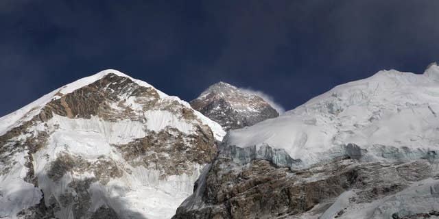 FILE - In this March 7, 2016 file photo, Mount Everest, in middle, altitude 8,848 meters (29,028 feet), is seen on the way to base camp. High winds have delayed dozens of climbers trying to reach the summit of Mount Everest, a mountaineer official said Wednesday, May 18, 2016. (AP Photo/Tashi Sherpa, File)