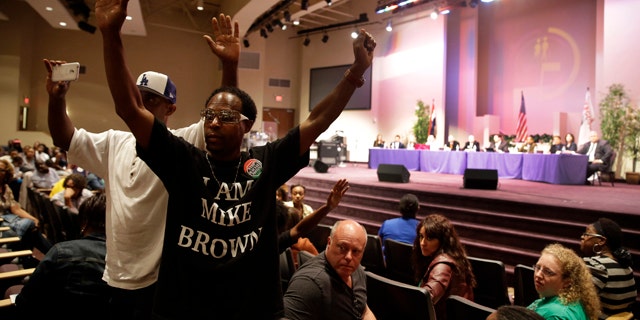 September 9, 2014: Maurice Brown raises his arms during a public comments portion of a meeting of the Ferguson City Council.