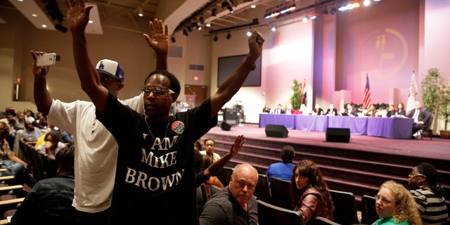 September 9, 2014: Maurice Brown raises his arms during a public comments portion of a meeting of the Ferguson City Council.