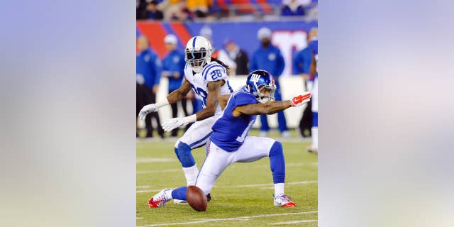 New York Giants' Odell Beckham, right, signals a first down after making a catch in front of Indianapolis Colts' Greg Toler (28) during the first half of an NFL football game Monday, Nov. 3, 2014, in East Rutherford, N.J. (AP Photo/Bill Kostroun)