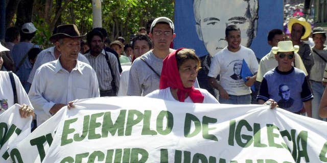 FILE - In this March 12, 2005, file photo, worshipers participate in a march to commemorate the anniversary of the death of Father Rutilio Grande, in Agulares, El Salvador. Grande was assassinated in 1977 by death squads during the civil war. The Catholic Church of El Salvador announced Wednesday, March 11, 2015, that they are preparing the process for the beatification of father Grande. (AP Photo/Edgar Romero, File)