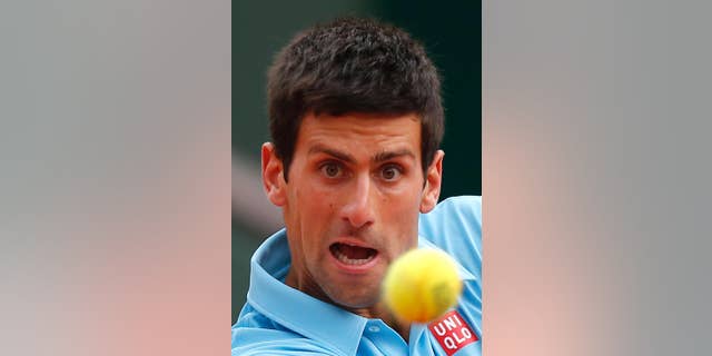 Serbia's Novak Djokovic eyes the ball as he plays France's Jo-Wilfried Tsonga during their fourth round match of the French Open tennis tournament at the Roland Garros stadium, in Paris, France, Sunday, June 1, 2014. (AP Photo/David Vincent)