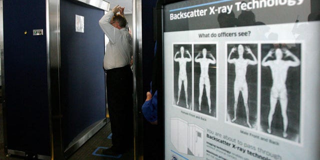 In this photo taken Sept. 1, 2010, Transportation Security Administration employee Anthony Brock, left, demonstrates a new full-body scanner at San Diego's Lindbergh Field, with TSA employee Andres Lozano in San Diego. The American Civil Liberties Union has denounced the machines as a "virtual strip search." Across the country, passengers must choose scans by full-body image detectors or probing pat-downs. Top federal security officials said Monday, Nov. 15, 2010, that the procedures were safe and necessary sacrifices to ward off terror attacks. (AP Photo/San Diego Union Tribune, Eduardo Contreras)