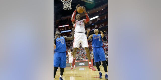 Houston Rockets' Dwight Howard (12) grabs a rebound between Dallas Mavericks Samuel Dalembert (1) and DeJuan Blair (45) in the first half of an NBA basketball game Friday, Nov. 1, 2013, in Houston. (AP Photo/Pat Sullivan)