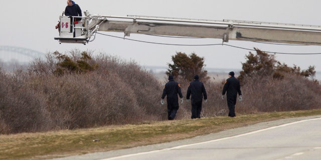 April 4, 2011: Police aided by a man in a fire department bucket ladder search in the brush near Oak Beach, N.Y. Three sets of human remains were found Monday, bringing to eight the total number of bodies found in the area since December.