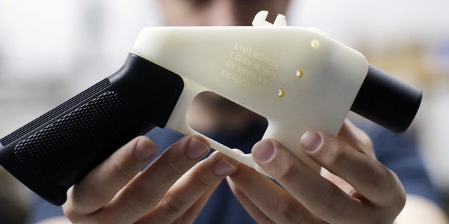 Cody Wilson, with Defense Distributed, holds a 3D-printed gun called the Liberator this month at his shop in Austin, Texas